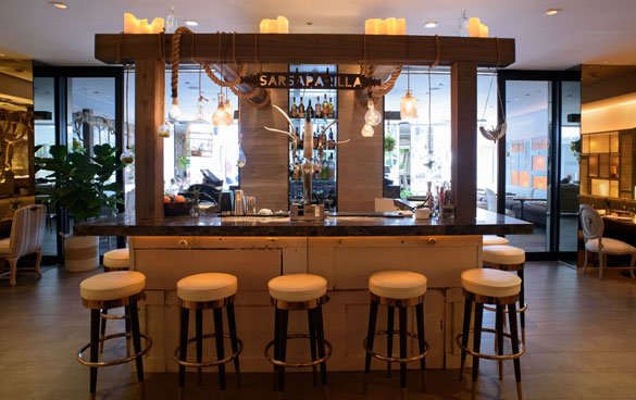 The Sarsaparilla Club bar is decorated with custom metal accents, draped rope lanyards and blown glass pendant lighting.