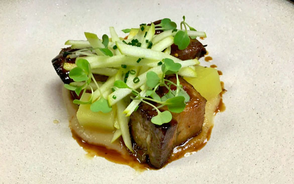 Chef Balloo's signature Roast Pork lechon topped with microgreens and tart granny smith apples