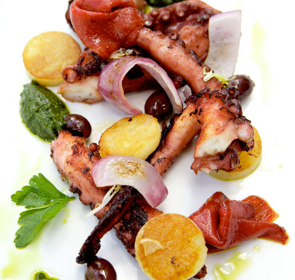 Grilled octopus is served with roast red peppers, kalamata olives, golden potatoes and salsa verde