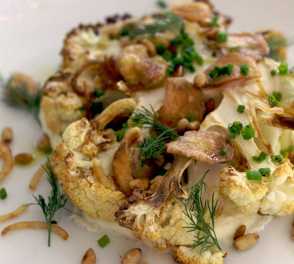 Chef Dubois' innovative Cauliflower Steak is topped with chives, nuts and crispy garlic chips